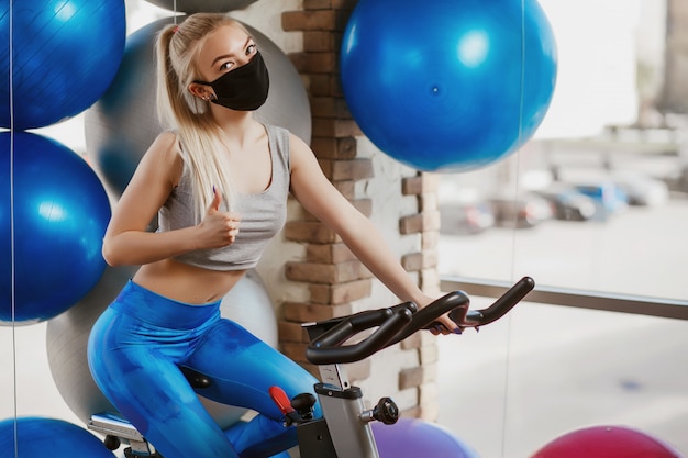 Máscaras protectoras contra la infección por virus. Entrenamiento durante la cuarentena en el gimnasio. Concepto de protección del coronavirus (COVID-19).