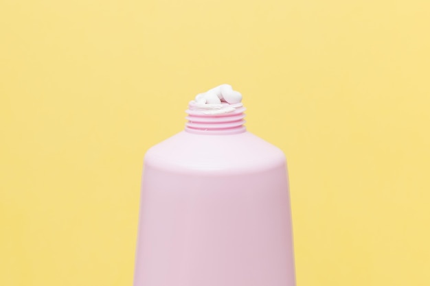 Mascarilla de arcilla en un tubo rosa sobre un fondo amarillo