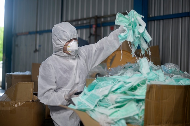 Mascarilla médica usada en plantas de reciclaje de residuos durante covid-19 y pandemia.