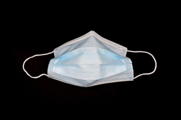 Mascarilla quirúrgica desechable usada o respirador médico nuevo de color azul Prevención COVID19 Medidas de seguridad H1N1 H5N1 Aisladas en fondo negro