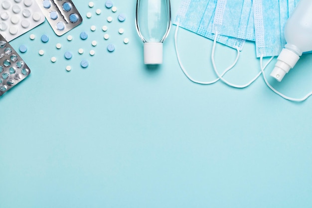 Mascarillas quirúrgicas, gel desinfectante para manos, esterilización y pastillas de fondo azul. Prevención contra el coronavirus.