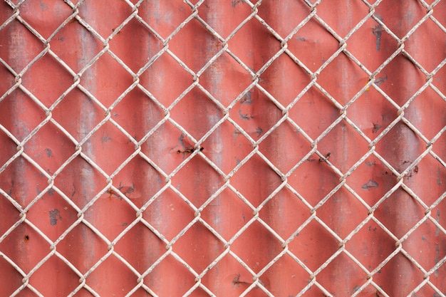 Maschendraht und roter gewellter Zaunhintergrund