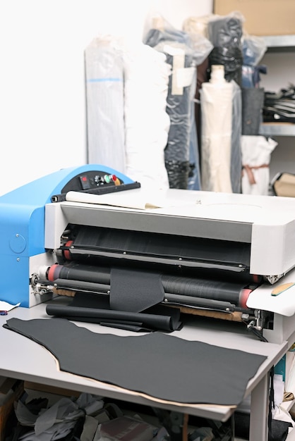 Maschine und Stoff auf weißem Tisch in einer professionellen Werkstatt