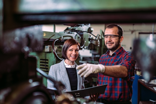 Maschinist, der mit weiblicher Aufsichtskraft an der Fabrik sich bespricht