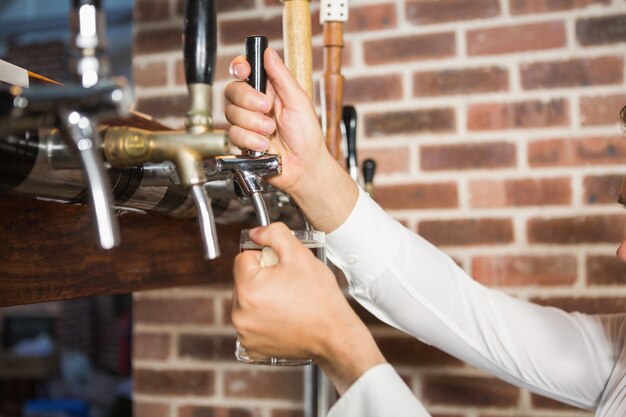 Masculinas mãos derramando cerveja