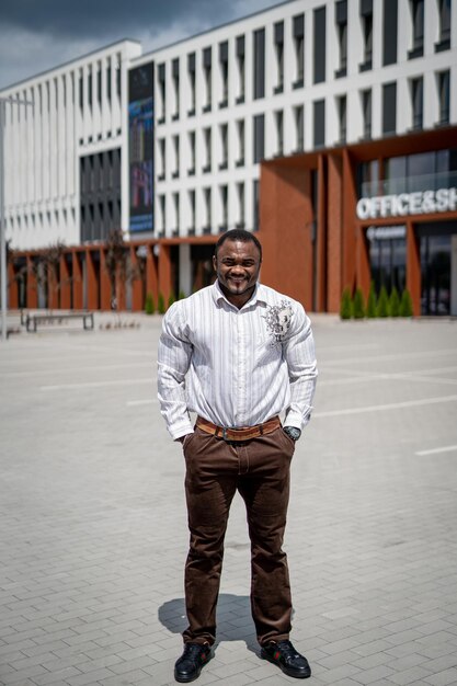 Masculino de moda ao ar livre em roupas casuais. empresário elegante bonito em pé na rua urbana da cidade moderna.