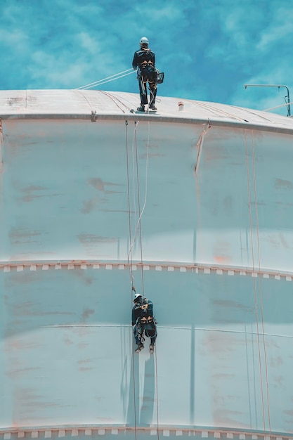 Masculino dois trabalhadores para baixo da altura do telhado do tanque de acesso à corda de inspeção de segurança solda de espessura do tanque de armazenamento de gás