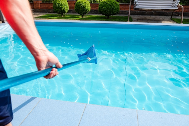 Foto masculino mão segura líquido de limpeza de piscina