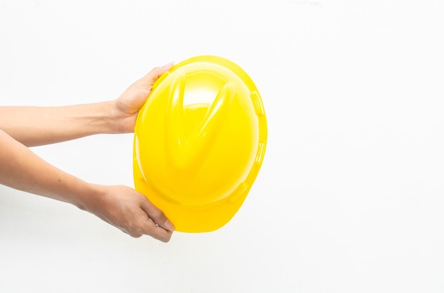 Foto masculino mão segurando capacete de segurança amarelo isolado sobre fundo branco. conceito de segurança do trabalho.