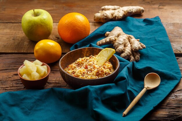 Masfouf de cuscuz com frutas secas e nozes em um prato em um guardanapo azul ao lado de frutas frescas