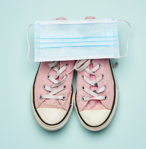 Maske und rosa Turnschuhe auf blau