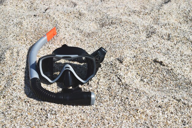 Maske zum Tauchen im Sand gegen das Meer