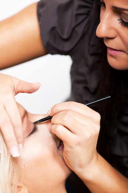 Maskenbildner, der Make-up auf schöne Frau aufträgt