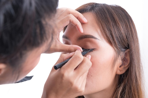 Maskenbildner ist Make-up ein asiatisches Frauenmodell auf weißem Hintergrund