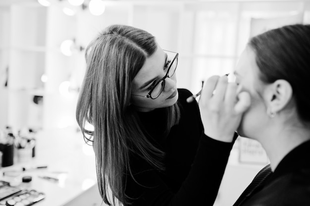 Maskenbildnerin arbeitet in ihrem Beauty-Studio-Salon. Die Frau, die durch Fachmann zutrifft, bilden Meister.