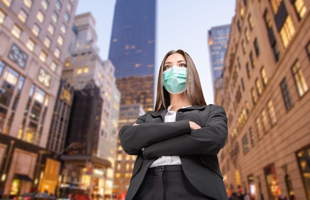 Maskierte Geschäftsfrau vor ihrem Büro-Coronavirus und Arbeitskonzept