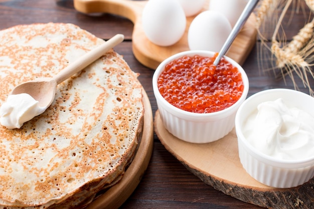 Maslenitsa-Festa-Pancakes mit rotem Kaviar und Sauerkrem auf dem Tisch Die russische Tradition