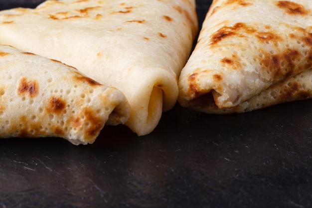 Maslenitsa russo, entrudo, semana de panqueca, carnaval, carnaval, dia de panqueca. uma pilha de panquecas com manteiga no andar de cima na chapa, superfície de madeira, close-up