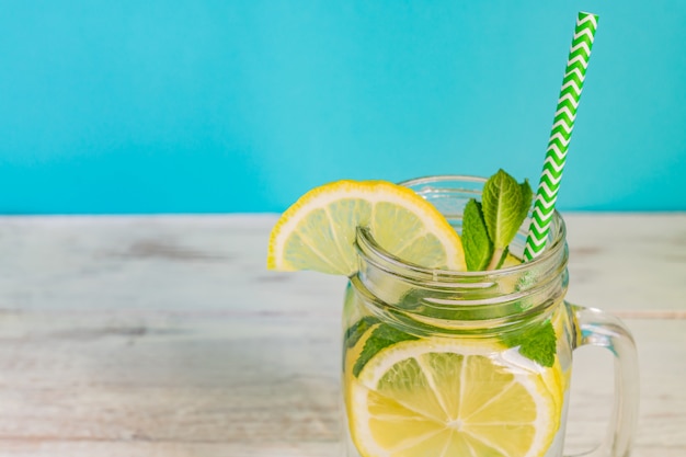 Foto mason jar copo de limonada caseira com limões, hortelã e palha de papel. bebida refrescante de verão.