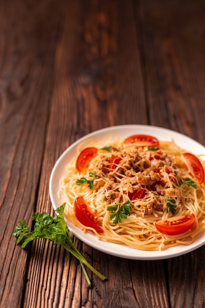 Massa à bolonhesa com molho de tomate e carne picada, queijo parmesão ralado e salsa fresca - massa italiana saudável caseira