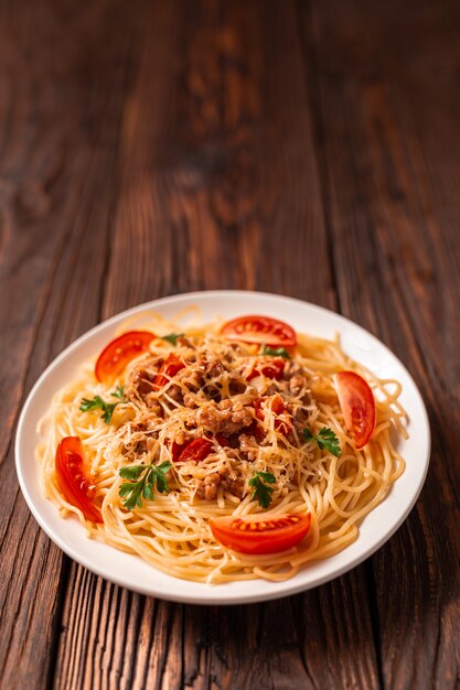 Massa à bolonhesa com molho de tomate e carne picada, queijo parmesão ralado e salsa fresca - massa italiana saudável caseira