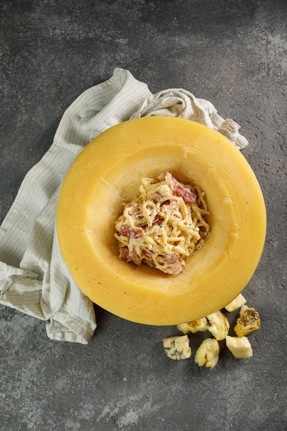 Massa Carbonara na cabeça de queijo em fundo de concreto