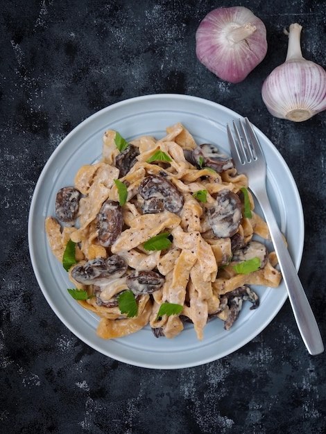 Massa caseira com cogumelos champignon e molho carbonara.