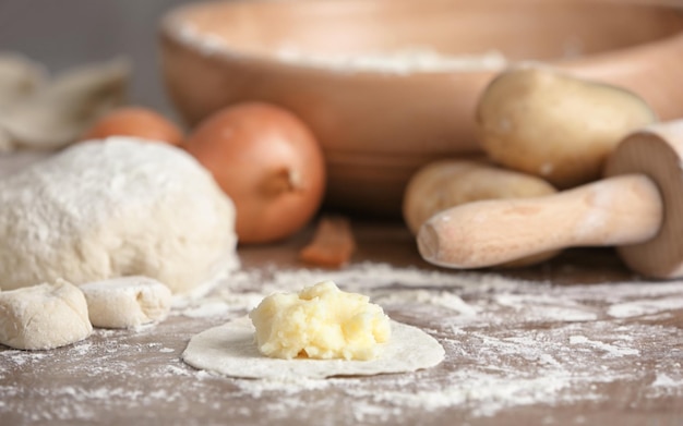 Massa crua com purê de batatas para bolinho na mesa de madeira