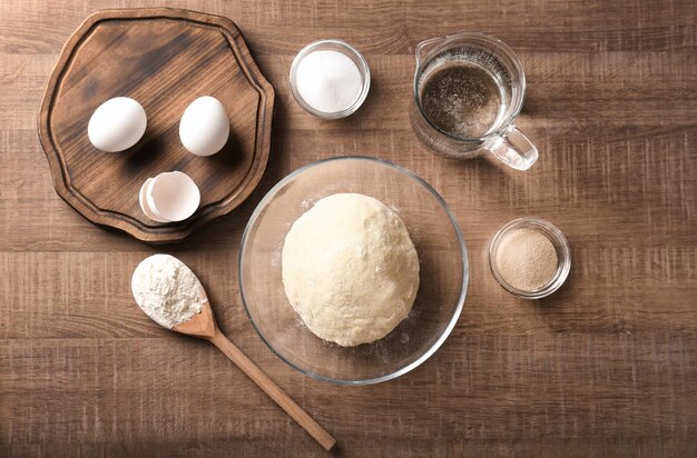 Massa crua e ingredientes na mesa da cozinha