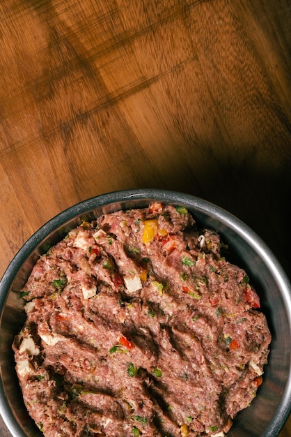 Foto massa de carne moída preparada para hambúrguer caseiro carne moída em tigela de metal sobre mesa de madeira