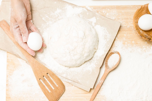 Massa de fermento crua em uma mesa de cozinha enfarinhada, ideia de receita. o conceito de cozinhar em casa ou fazer massa. rolo da massa para massa