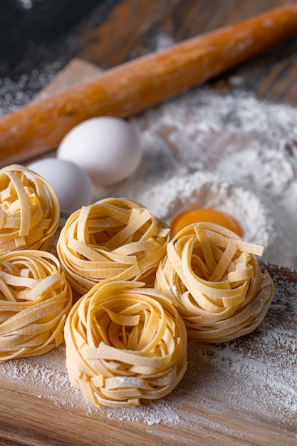 Massa de fettuccine caseira dobrada em forma de ninho Cozinha caseira com ingredientes para massa de fettuccine italiana tradicional caseira