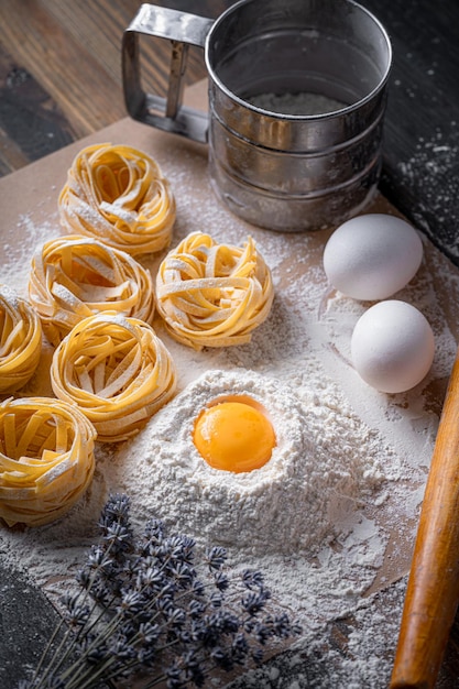 Massa de fettuccine caseira dobrada em forma de ninho Cozinha caseira com ingredientes para massa de fettuccine italiana tradicional caseira