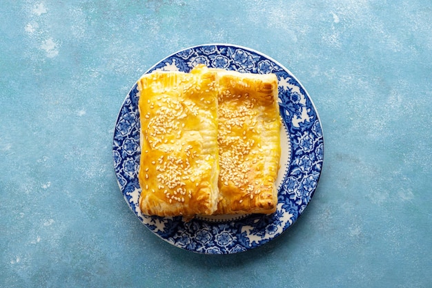 Massa de massa folhada Torta de massa folhada assada dobrada em um prato de fundo azul