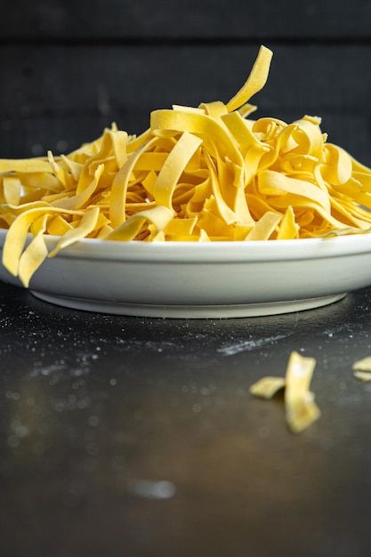 Massa de ovo massa crua tagliatelle cozinhando farinha de trigo duro feito à mão na mesa