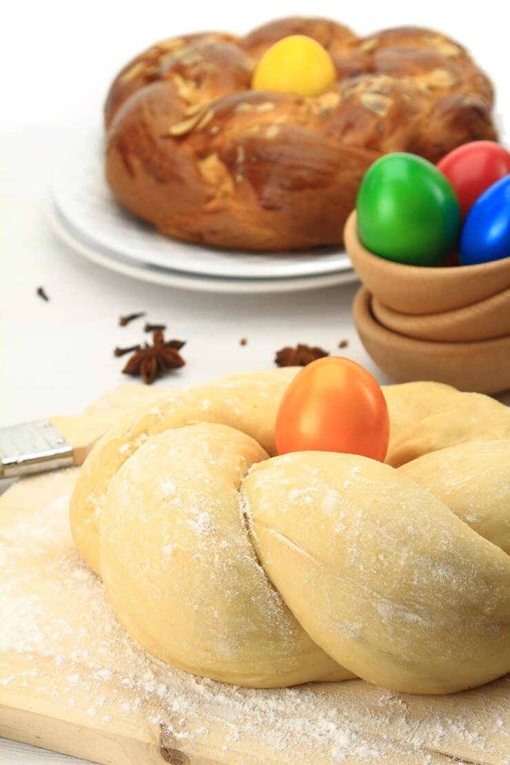 Foto massa de pão doce de páscoa com ovos multicoloridos