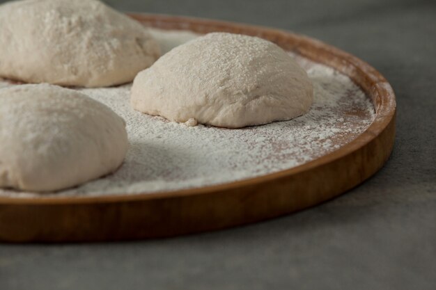 Massa de pizza e farinha na tábua