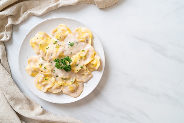 Foto massa de ravióli com molho de creme de cogumelos e queijo - comida italiana