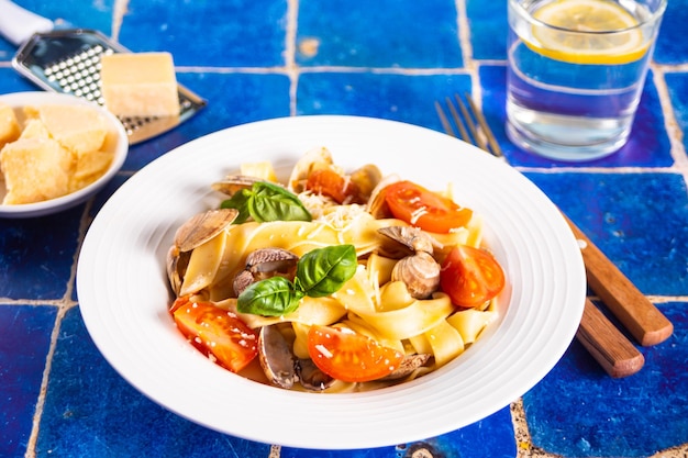 Massa de ravioli italiana tradicional caseira com manjericão e tomate cereja vegetais em cima da mesa