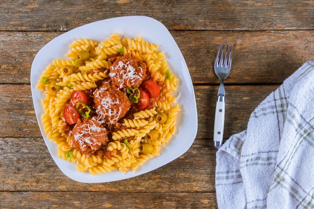 Massa de Rotini com os meatballs no molho e nas azeitonas de tomate na bacia.