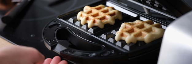 Massa de waffle assando na máquina de waffle closeup