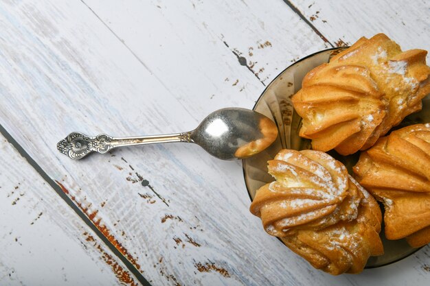 Massa e colher de choux, em de madeira. feche o creme choux. com uma colher e um garfo de metal