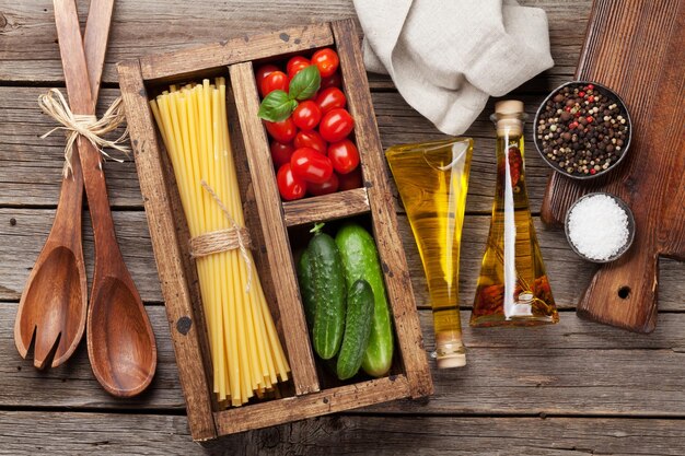 Foto massa e ingredientes tomate manjericão pepino conceito de culinária vista superior