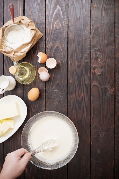 Massa e produtos para sua preparação em mesa de madeira escura