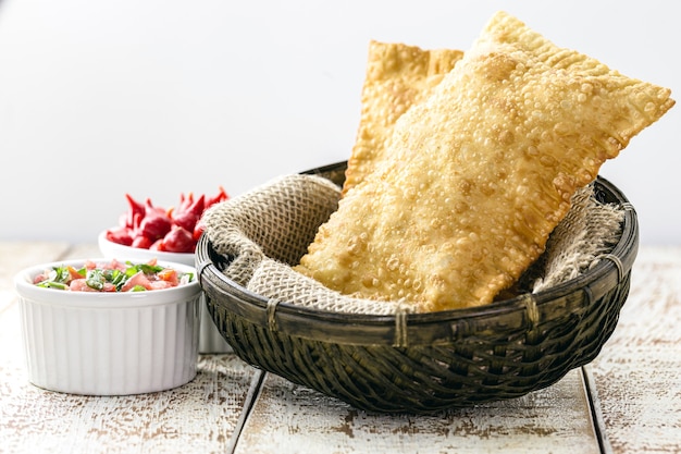 Massa frita com batata, molho picante servido quente.