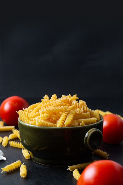 Massa fusilli em tigela de cerâmica verde com ingredientes