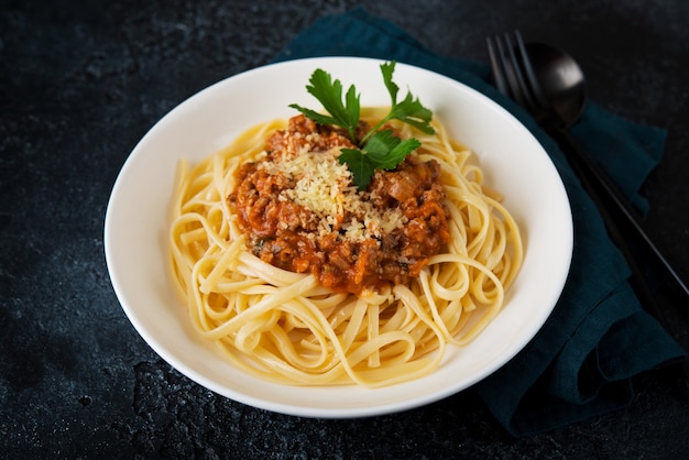 Massa italiana à bolonhesa com verduras em fundo preto, close-up