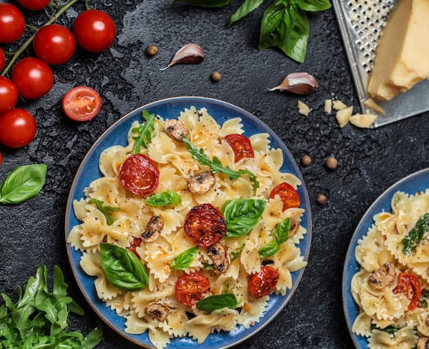 Massa italiana com molho, tomate cereja, manjericão e queijo parmesão. Prato de massa deliciosa