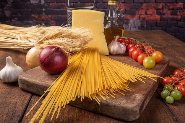 Massa italiana, espaguete, tomate, azeite, queijo e especiarias em madeira rústica