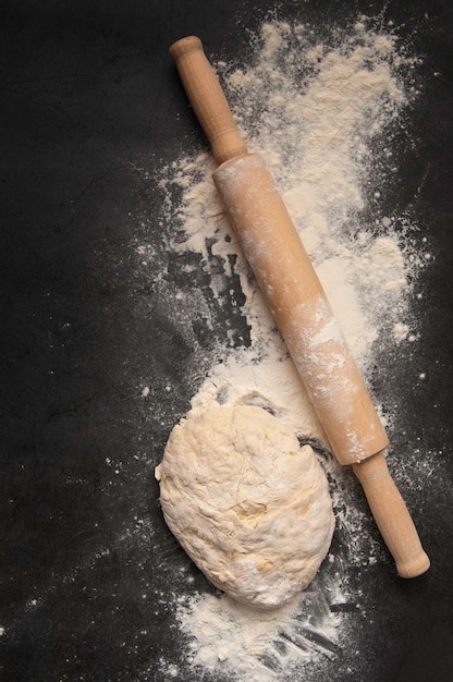 Foto massa para pizza e rolo na mesa de madeira